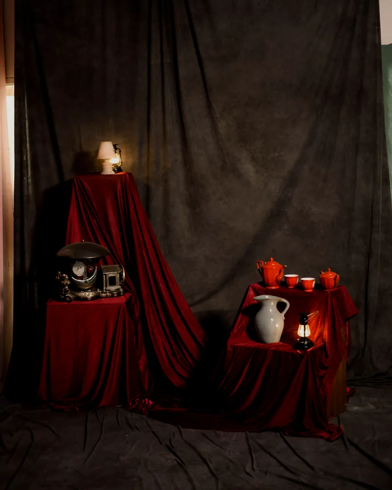 Dramatic red still life with small objects arranged on a table